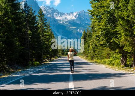 Eine Frau, die auf der Straße im Valbona-Tal, Theth-Nationalpark, Albanischen Alpen, Valbona Albanien spaziert Stockfoto