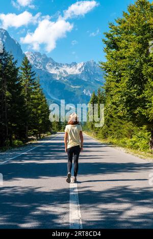 Eine Frau, die auf der Straße im Valbona-Tal, Theth-Nationalpark, Albanischen Alpen, Valbona Albanien spaziert Stockfoto