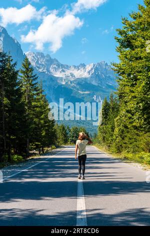 Ein junges Mädchen, das auf der Straße im Valbona-Tal, Theth-Nationalpark, Albanischen Alpen, Valbona Albanien spaziert Stockfoto