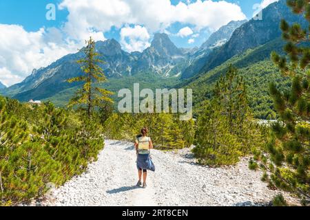 Wanderfrauen, die im Valbona-Tal neben Bäumen, Theth-Nationalpark, Albanischen Alpen, Albanien spazieren gehen Stockfoto