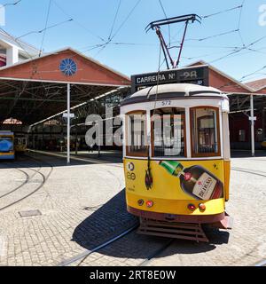 Historische gelbe Straßenbahn, Elektrik, Linie 28 vor Straßenbahndepot und Reparaturwerkstatt, Lissabon, Portugal Stockfoto