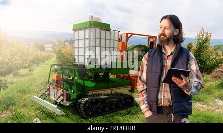 Die autonome Roboterspritze arbeitet in einem Obstgarten. Konzept der intelligenten Landwirtschaft Stockfoto