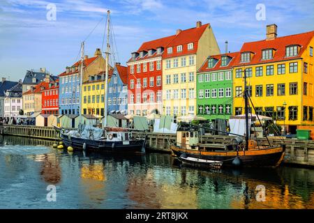 Bunte Gebäude und Schiffe am Ufer entlang des historischen Nyhavn-Kanals mit Reflexionen, Kopenhagen, Dänemark Stockfoto