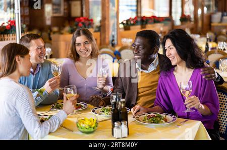 Glückliche Erwachsene, die sich beim Abendessen im Restaurant amüsieren Stockfoto