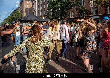 Junge Menschen tanzen auf der Straße bei der Kallio Block Party 2023 in Helsinki, Finnland Stockfoto