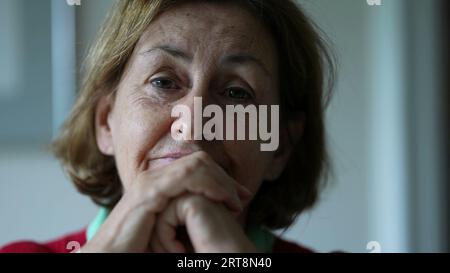 Ältere Frau, die sich anlehnt, um Gespräche zu hören, Nahaufnahme einer Seniorin Stockfoto