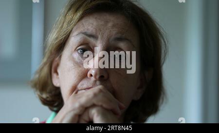 Ältere Frau, die sich anlehnt, um Gespräche zu hören, Nahaufnahme einer Seniorin Stockfoto