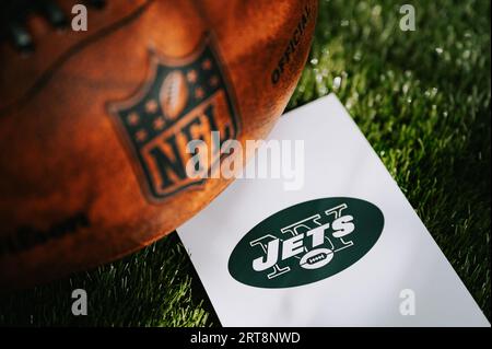 NEW YORK, USA, 11. SEPTEMBER 2023: New York Jets Logo auf dem Boden und offizieller NFL-Ball auf grünem Gras. Jets-Karte, Bereich bearbeiten Stockfoto