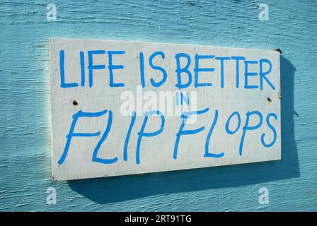 Das Leben ist besser in Flip Flops Sign, Strandhütten, Small Hope Beach, Shanklin, Isle of Wight, Hampshire, England. Stockfoto