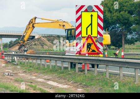 Bau einer Straße und Kommunikation für den Bau. Der Planierschild bereitet sich vor Stockfoto