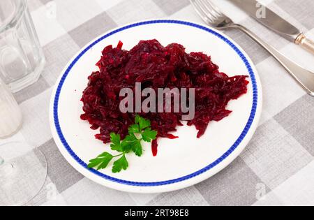 Salat aus geriebener, gebackener Rote Bete auf dem Teller mit frischer Petersilie Stockfoto