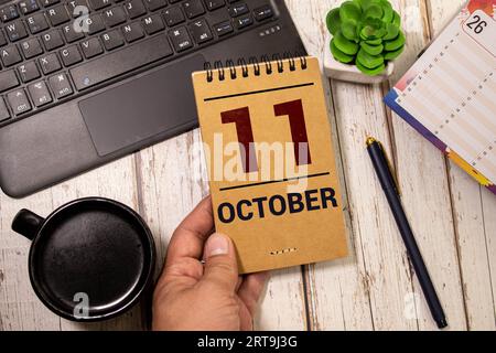 Weißer Block Kalender präsentieren Datum 11 und Monat Oktober auf Holz Hintergrund. Stockfoto