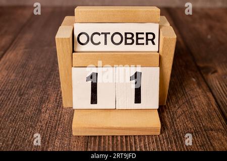 Weißer Block Kalender präsentieren Datum 11 und Monat Oktober auf Holz Hintergrund. Stockfoto