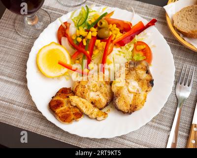 Gebratene Kabeljausteaks mit Zitronen- und Gemüsesalat Stockfoto