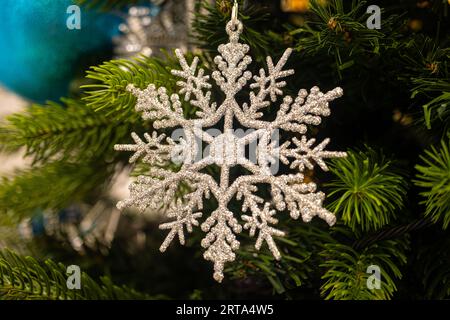 Nahaufnahme einer Weihnachtsdekoration mit Schneeflocke, die an einem Weihnachtsbaum hängt Stockfoto