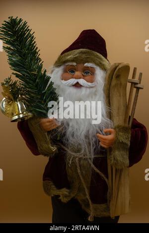 Weihnachtsmann-Spielzeug mit Holzskiern und Tannenzweig mit Glocke Stockfoto