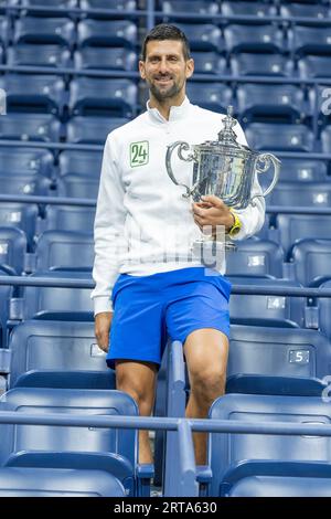 Novak Djokovic, Gewinner der US Open-Meisterschaft der Männer, posiert am 10. September 2023 im Billie Jean King Tennis Center in New York mit der Trophäe im Arthur Ashe Stadion. Stockfoto