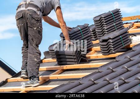 Keramikfliesen auf dem Dach, Installation eines neuen Daches durch einen Experten Stockfoto