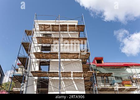 Altes Gebäude im Umbau. Gerüste in der Nähe der Fassade eines Gebäudes für Restaurierungsarbeiten. Stockfoto