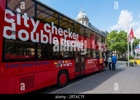 Düsseldorf, Deutschland - 2. Juni 2022: Hop-on-Hop-off-Sightseeing-Bus in der Stadtstraße, der an einer Haltestelle im Zentrum von Düsseldorf, Nort, auf Touristen wartet Stockfoto