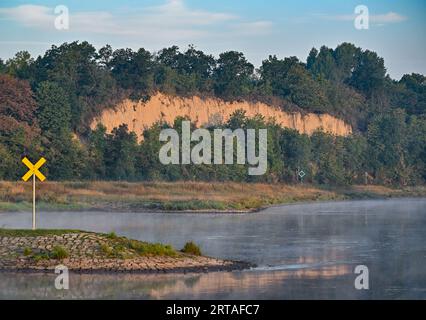 Brieskow Finkenheerd, Deutschland. September 2023. Im Licht des Sonnenaufgangs leuchtet die Steile Wand, ein Hochufer am Brieskower See, an der Mündung in die deutsch-polnische Grenzfluss oder. Über dem Hochufer befindet sich ein wichtiges archäologisches Denkmal - der Lossower Burgwall. Der Burgwall von Lossow, ein Stadtteil der Stadt Frankfurt (oder), war in der Bronzezeit ein befestigtes Burgzentrum. Quelle: Patrick Pleul/dpa/Alamy Live News Stockfoto