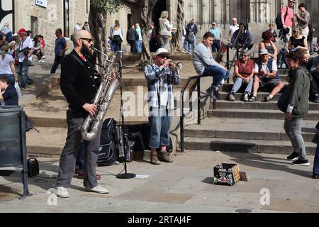 BARCELONA, SPANIEN - 10. MAI 2017: Nicht identifizierte Straßenmusiker spielen für Passanten im historischen Zentrum der Stadt. Stockfoto