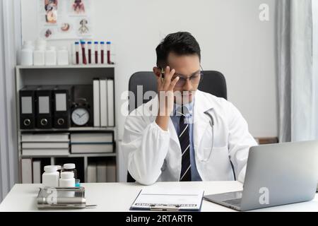Mann asiatisches Lächeln Arzt Denken und Patienten verwenden Computer, um medizinische Fachkraft oder Beratung im Krankenhaus Konferenzgespräch, Telemedizin Gesundheitswesen zu erklären Stockfoto