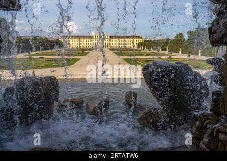 Blick durch den Neptun-Brunnen zum Schönbrunn-Park und Schloss, UNESCO-Weltkulturerbe in Wien, Österreich, Europa Stockfoto