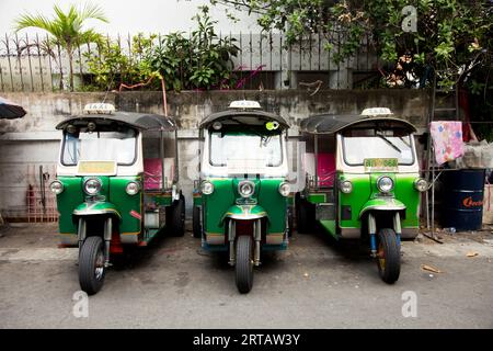 Bangkok, Thailand; 1. Januar 2023: Drei Tuk Tuks in einer Reihe auf einer Stadtstraße. Stockfoto