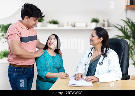 Indische Frauenärztin, die junge verheiratete Paarpatienten in der Kinderwunschklinik über IVF oder IUI berät. Schwangerschaftsplanung. Stockfoto