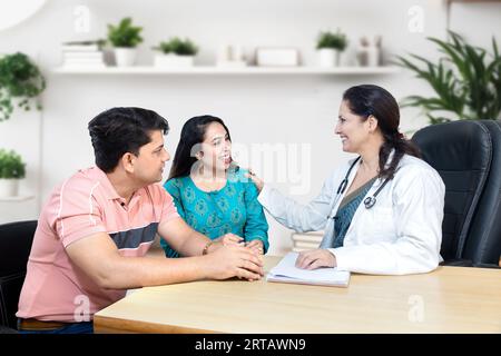 Indische Frauenärztin, die junge verheiratete Paarpatienten in der Kinderwunschklinik über IVF oder IUI berät. Schwangerschaftsplanung. Stockfoto