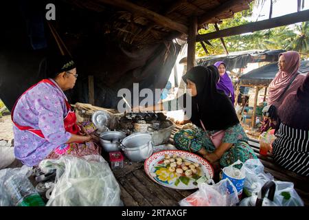 Sichon, Thailand; 1. Januar 2023: Frau bereitet Kokosnuss-thai-Desserts zu. Kanom krok ist eine leckere thailändische Mini-Pfannkuchen-Straße auf Kokosmilch-Basis Stockfoto