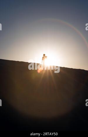 Silhouette eines Mannes, der auf einer Gipsdüne des White Sands National Monument in New Mexico steht. Stockfoto