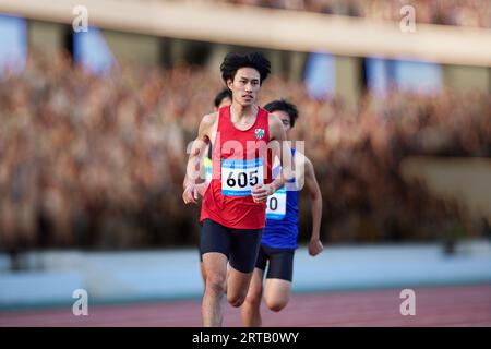Japanische Athleten laufen auf der Rennstrecke Stockfoto