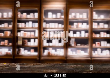 Dunkler Holzzähler mit verschwommenen Apothekenregalen, ideal für Produktpräsentationen oder Modelle. Stockfoto