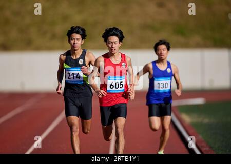 Japanische Athleten laufen auf der Rennstrecke Stockfoto