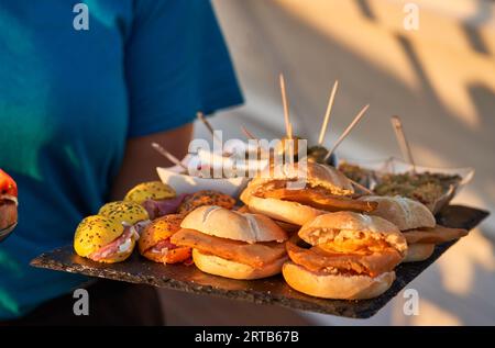 Die Kellnerinnen servieren im mediterranen Sommer eine köstliche Mahlzeit an der Strandbar. Lifestyle-Konzept Stockfoto