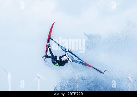 Windsurfer springen vor Windturbinen, Ostsee, Schleswig-Holstein, Deutschland Stockfoto