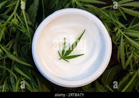 Gefäße aus Hanfcreme und Hanfblättern auf Holztisch, flach gelegt. Bio-Kosmetik Stockfoto