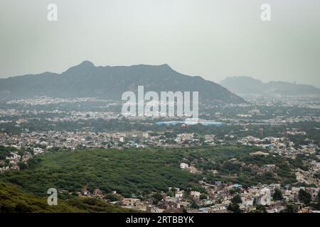 Überfüllte Stadthäuser Landschaft mit nebelnem Berg Hintergrund am Morgen aus flachem Winkel Bild wird in ajmer rajasthan indien aufgenommen Stockfoto