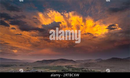 Eine atemberaubende und dramatische Landschaft mit einem beleuchteten Himmel voller wogender Wolken. Stockfoto
