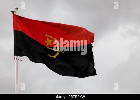 Die angolanische Flagge weht auf ihrem Pol. Stockfoto