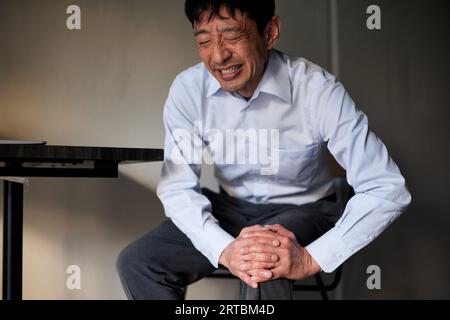 Japanischer Mann unter Schmerzen Stockfoto