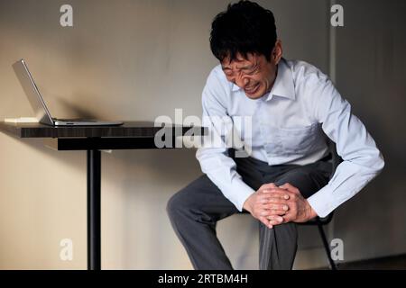 Japanischer Mann unter Schmerzen Stockfoto