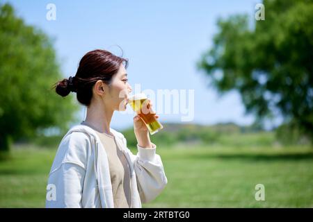 Japanische Frau trinkt Bier Stockfoto