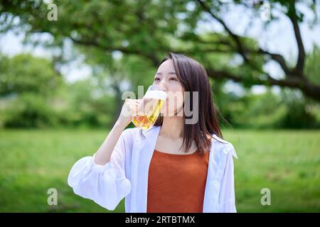 Japanische Frau trinkt Bier Stockfoto