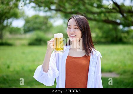 Japanische Frau trinkt Bier Stockfoto