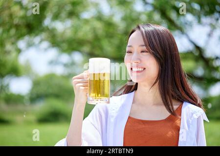 Japanische Frau trinkt Bier Stockfoto