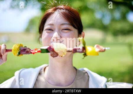 Japanische Frau beim Grillen im Stadtpark Stockfoto