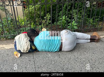 Ein Obdachloser schläft auf einem Bürgersteig im Wohnviertel Park Slope in Brooklyn, New York. Stockfoto